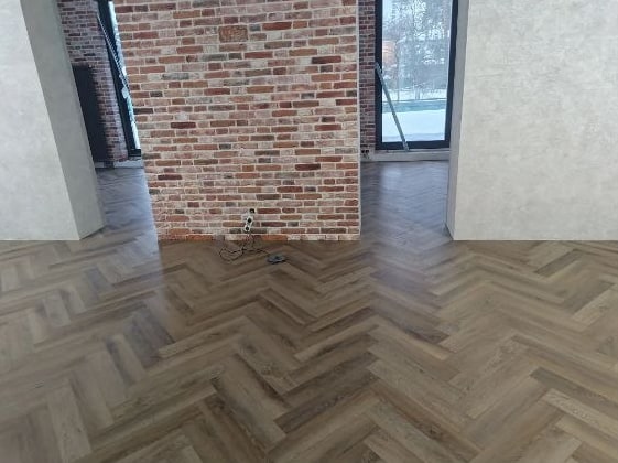 Кварцвинил ёлочкой у кирпичной стены